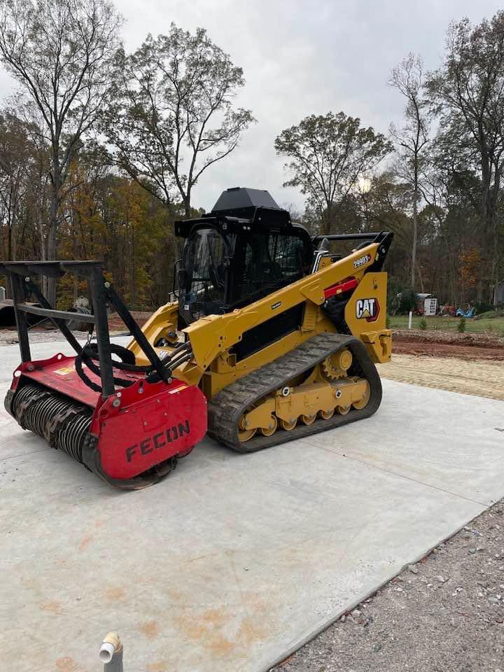 CAT skid steer with red Fecon mulcher attachment